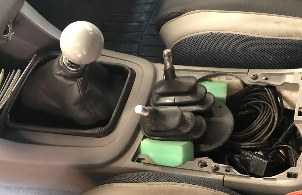 3D Printed shift knobs displaying modified shift patterns, both held in place with large heat set fasteners
